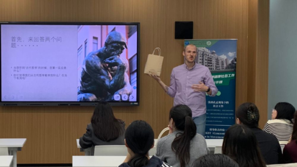 MSW student Carson Ramsdell presents at the front of a classroom as other students listen.