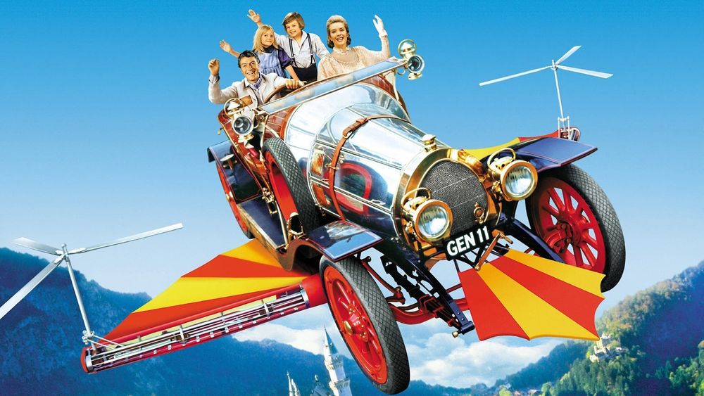 Chitty Chitty Bang Bang car flying over the mountains while the family inside waves.