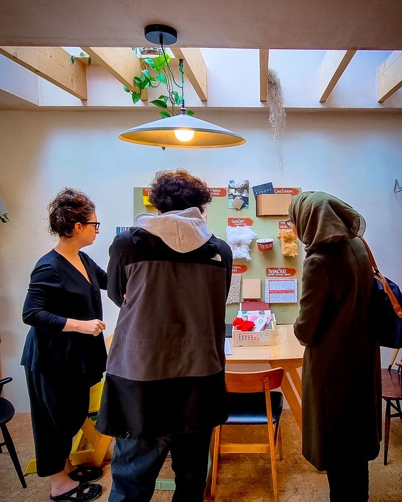 3 people stood around a board with information about retrofit on it