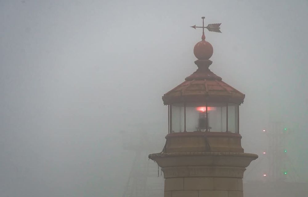 The weather vane and red light at the top of Ramsgate lighthouse, seen through the mist
