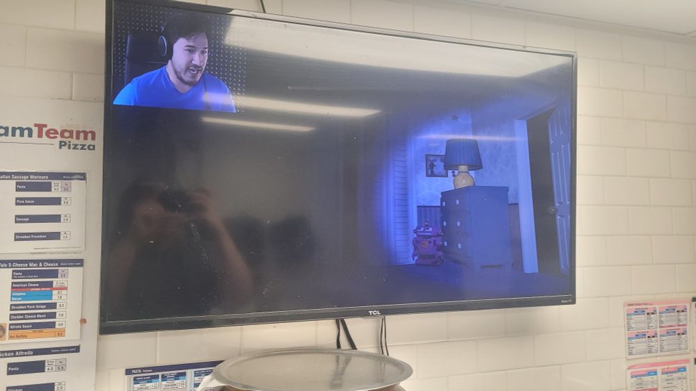 a picture of a tv at my workplace, with a video of markiplier playing fnaf 4 playing