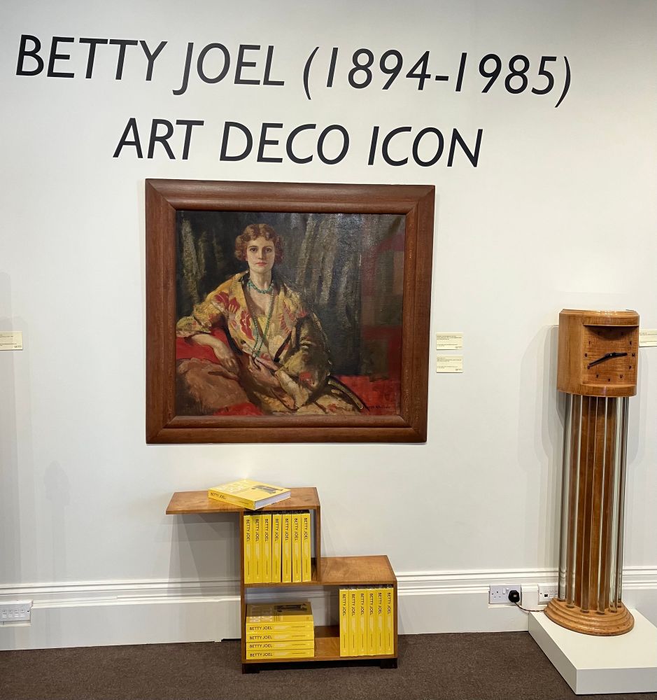 Portrait of Betty Joel, and shelf unit and tall clock designed by Betty. 