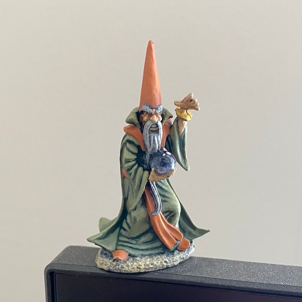 A hand-painted miniature wizard with pointy hat and crystal ball. 