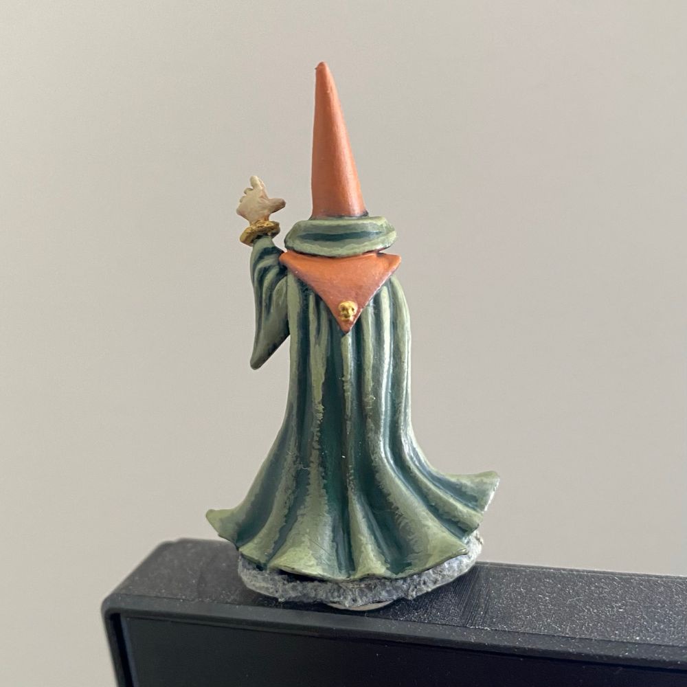 Detail on the cape of a hand-painted miniature wizard with pointy hat and crystal ball. 