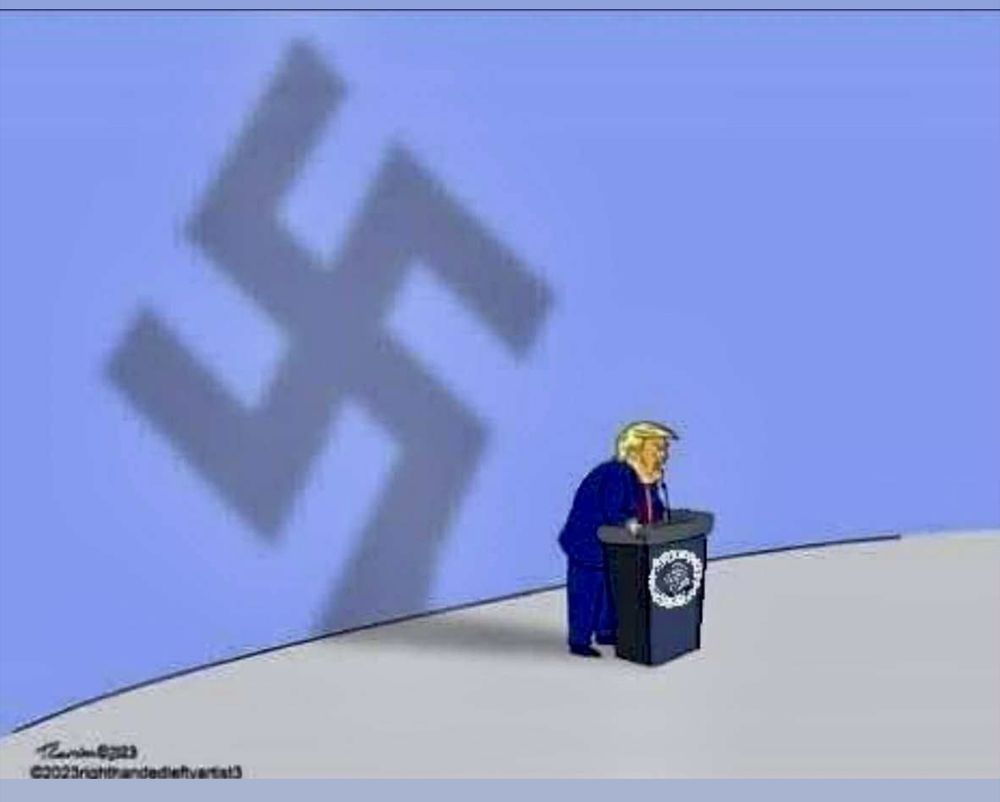 Trump standing at a podium, the light casting his shadow on the wall behind which appears as a swastika.
