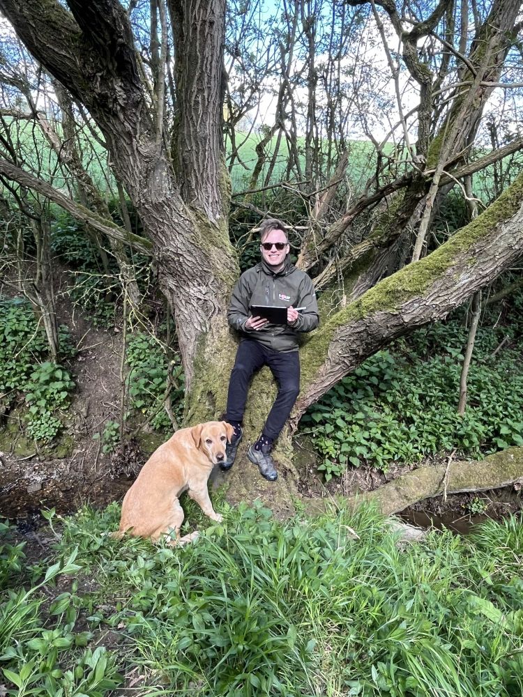 Photograph of Henry and his dog Polly sitting by a tree.