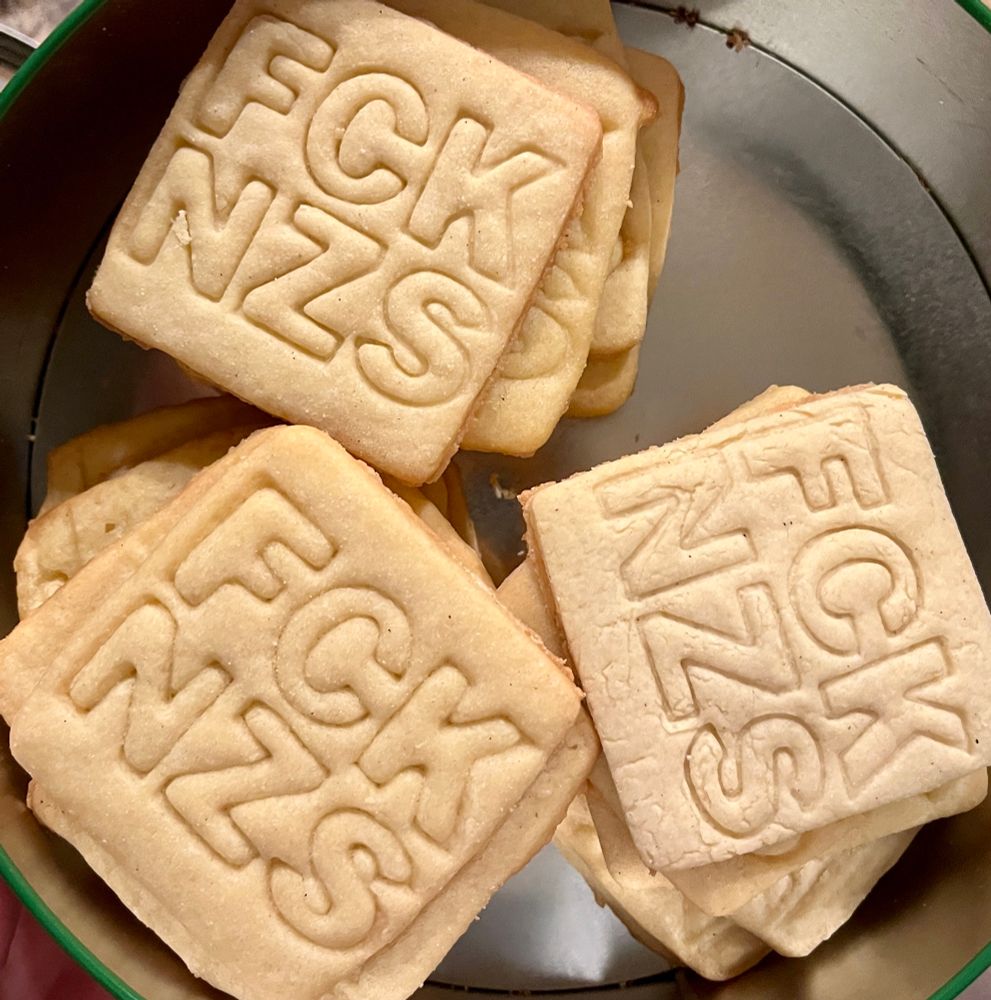 Tin of cookies that have FCK NZS printed on them.