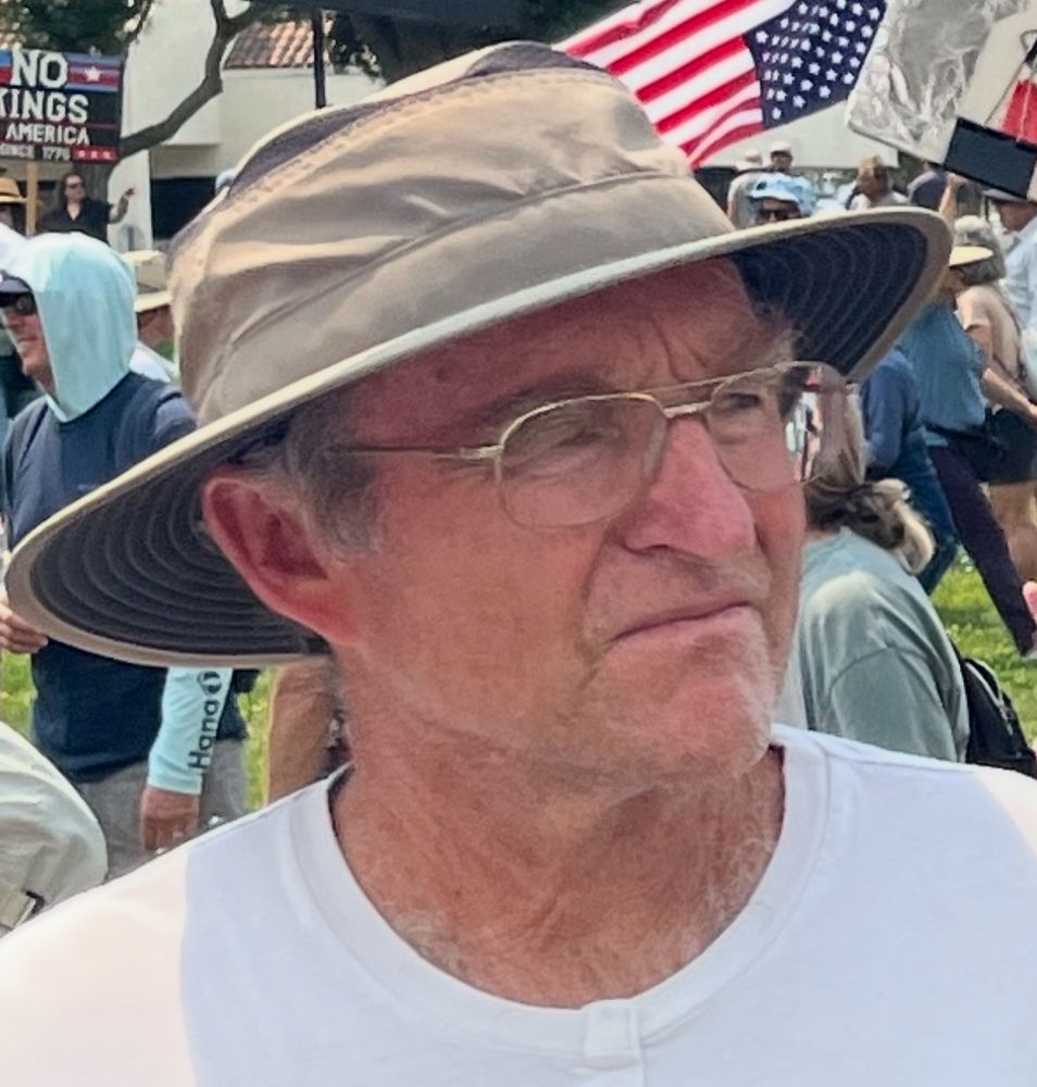 Angry looking man with reading glasses and a corny safari hat. 