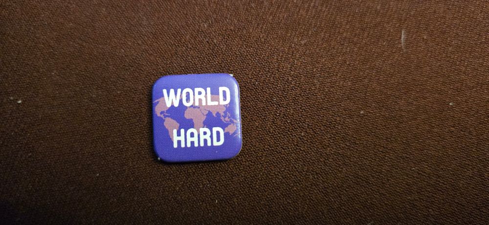 A purple token from the GMT board game "Labyrinth: The War on Terror" that reads "World Hard".
