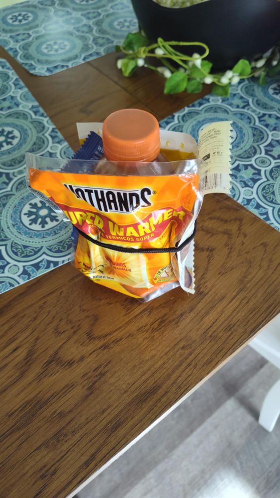 photo of a snack kit for use by an unhoused neighbor

snack kit includes: a hand warmer, an epic meat bar, nature's bakery fig bars, a bar D shower wipe

it is all banded together with a black hair tie and is sitting on a table
