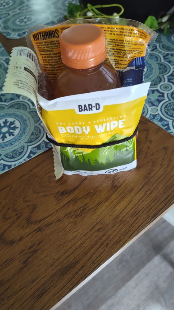 photo of a snack kit for use by an unhoused neighbor

snack kit includes: a hand warmer, an epic meat bar, nature's bakery fig bars, a bar D shower wipe

it is all banded together with a black hair tie and is sitting on a table