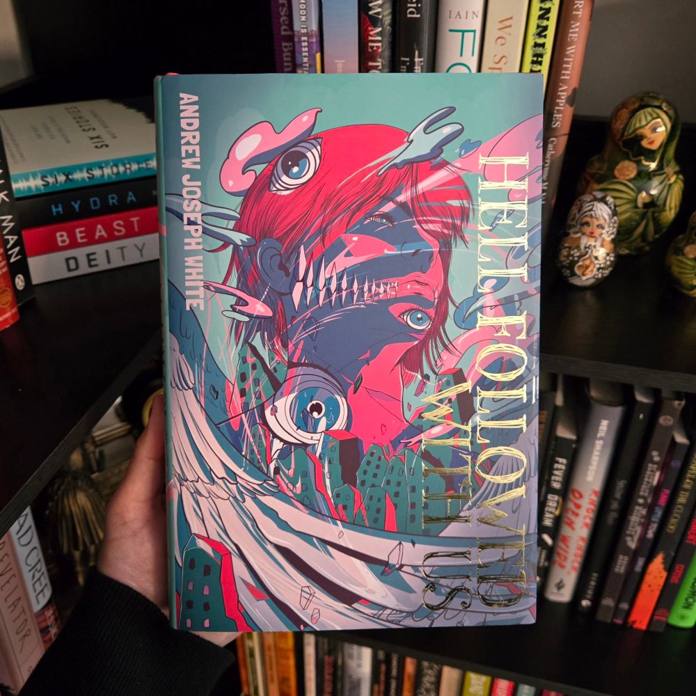 Close up of Evernight's exclusive edition of Amdrew Joseph White’s Hell Followed With Us, with full bookcase in the background. 