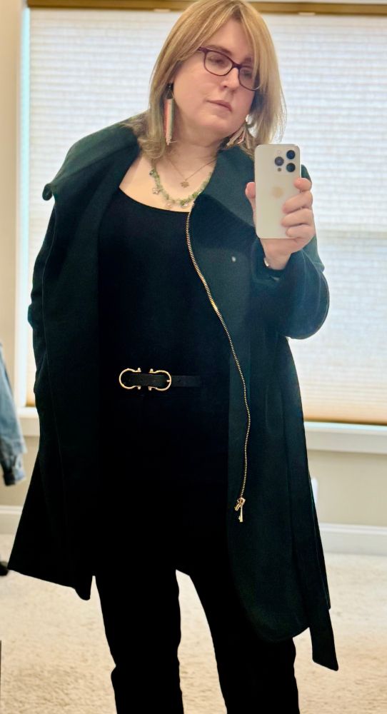 a woman poses for a selfie in the mirror. ahe is wearing the same as the previous outfit, but has switched her olive hoodie for a green karl lagerfeld wool jacket with gold accents; her belt (twin loops in gold) is also visible in this photo