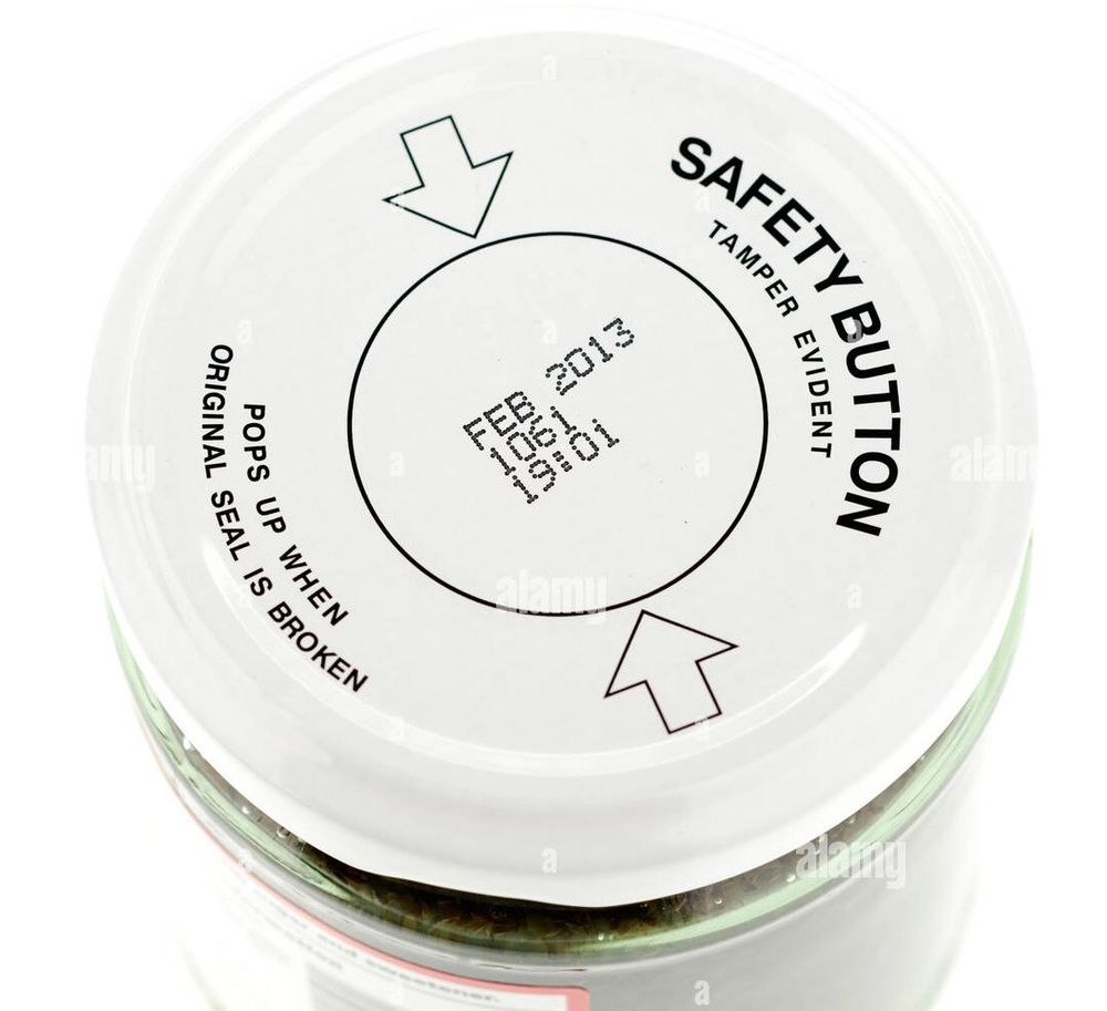 a safety lid for an openable jar, labeled “tamper evident safety button”, of the type that makes a popping sound when you press the button
