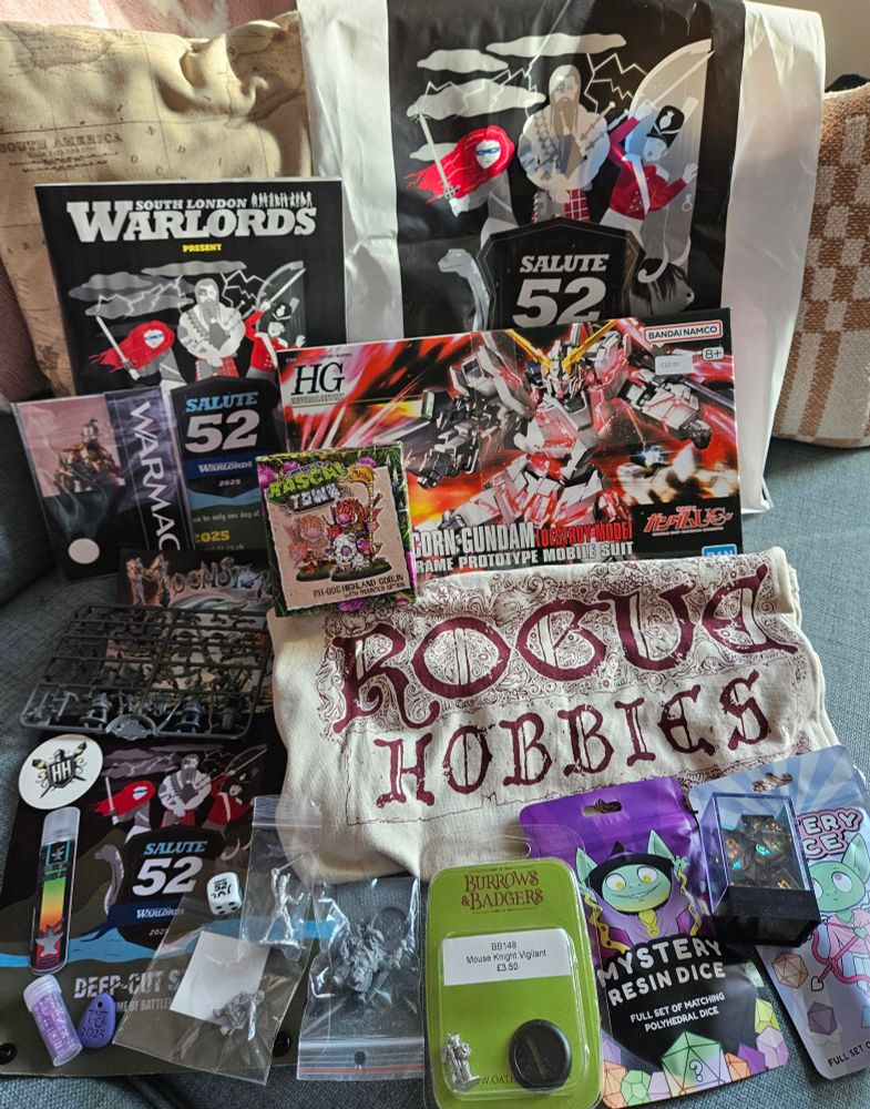 Haul of goodies from Salute52 including Gundam, minatures, dice,  rogue hobbies tshirt and rascal town mini.