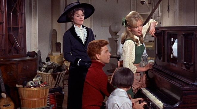 A frame of people around a piano from the film summer magic