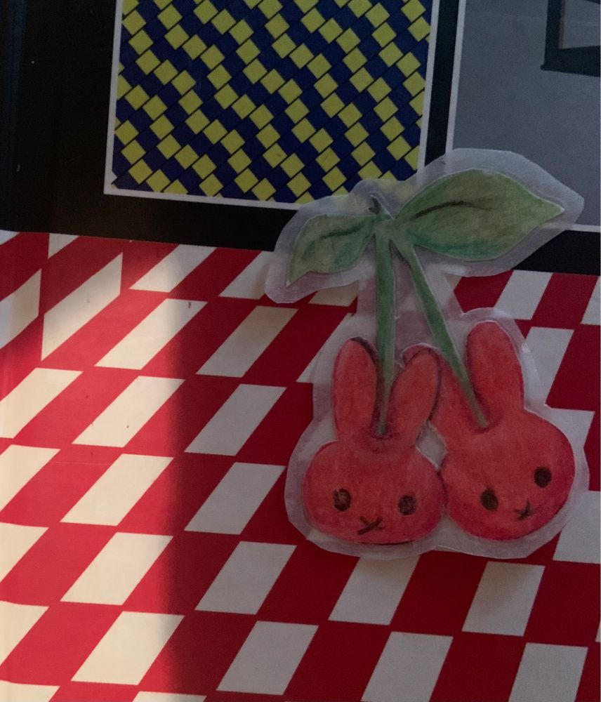 Homemade red, cherry miffy stickers, on an optical illusions book