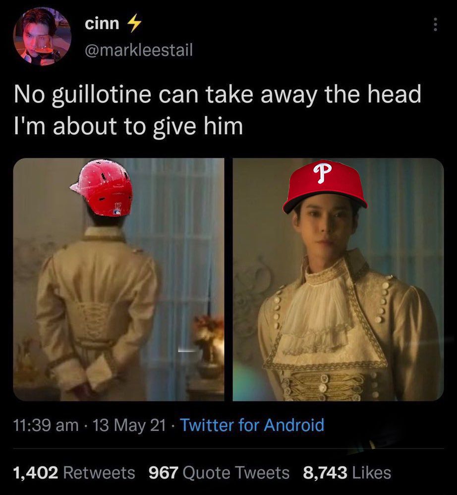 screenshot of a tweet in which doyoung from nct is wearing a phillies hat: no guillotine can take away the head I’m about to give him