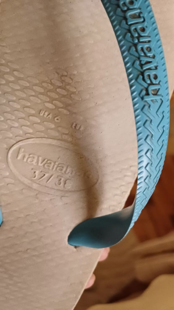 Chinelo da marca Havaianas branco com tira azul