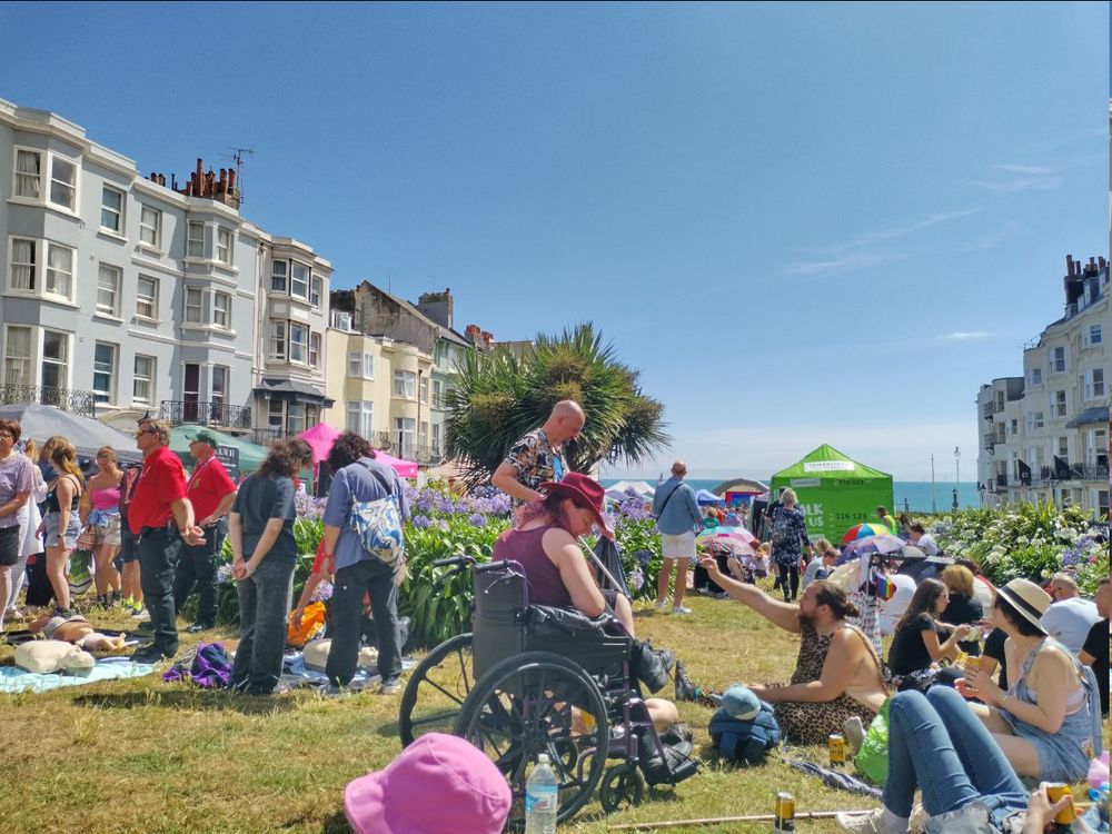 A photo of one of the open gardens, with queer people sitting around and celebrating trans pride