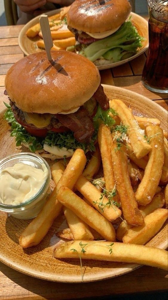 A screenshot of a fancy(?) bacon cheeseburger with French fries 