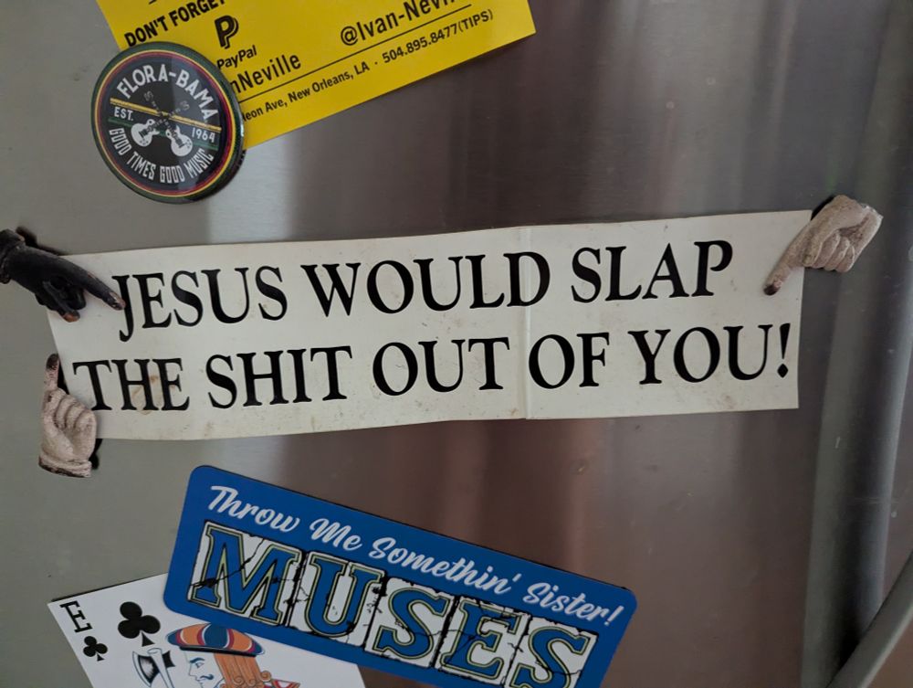 A photo of my fridge door with a "JESUS WOULD SLAP THE SHIT OUT OF YOU" bumper sticker on it.