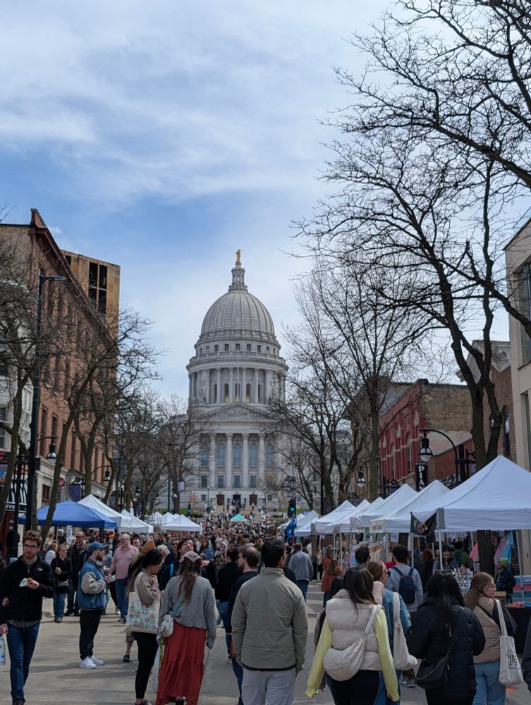 The Wisconsin Capitol building captured from a street with the market vendors pictured. 