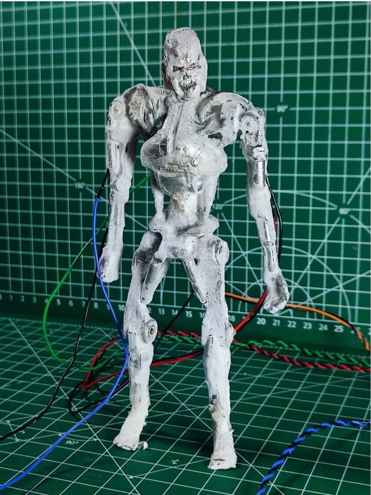 Super creepy looking humanoid robot with red eyes, a metallic grin, and frothy white fungus "skin".