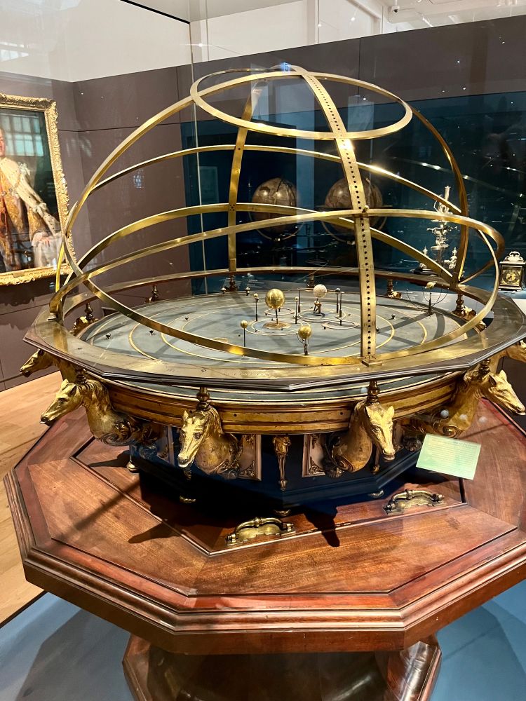 This ornate orrery was owned by Queen Caroline, wite of King George It was originally installed in her gallery at Kensing malace Caroline took a keen interest in science ano and discussed ideas and experiments with philosooners including Isaac Newton. Both she and King George Ill's wife, Queen Charlotte, possessed fine collections of scientific books and instruments, which they shared with their children.
Modified and enlarged by Thomas Wright, Fleet Street, London Lent by King's College London. Object no. 1927-1659

Text from display 