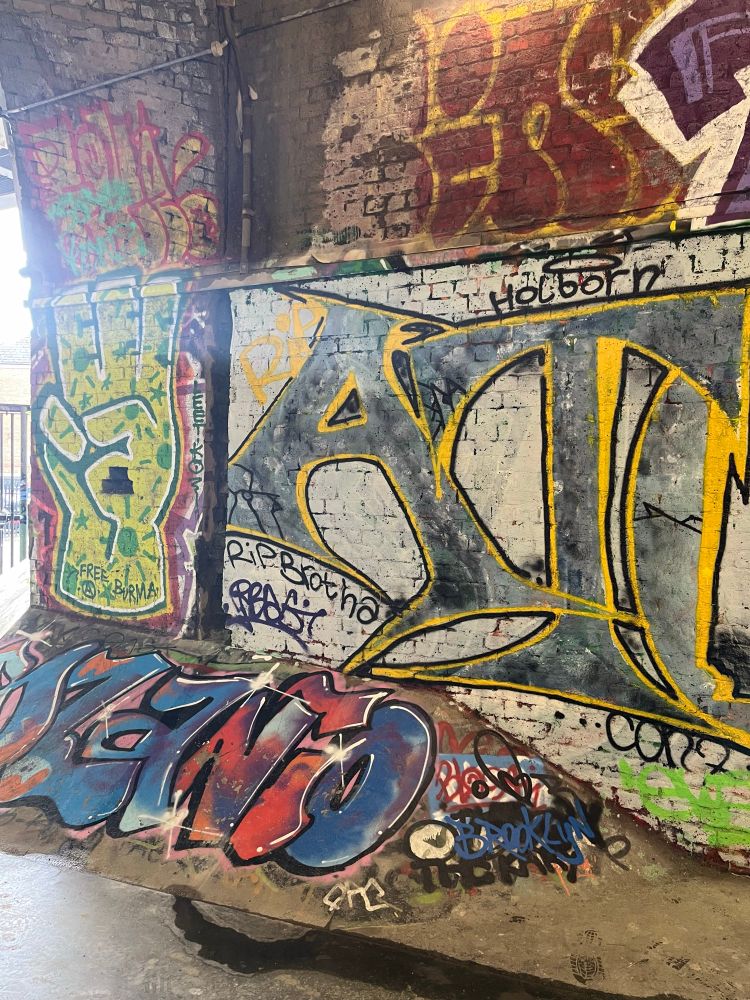 Railway arches turned skatepark brick walls with graffiti on ramps