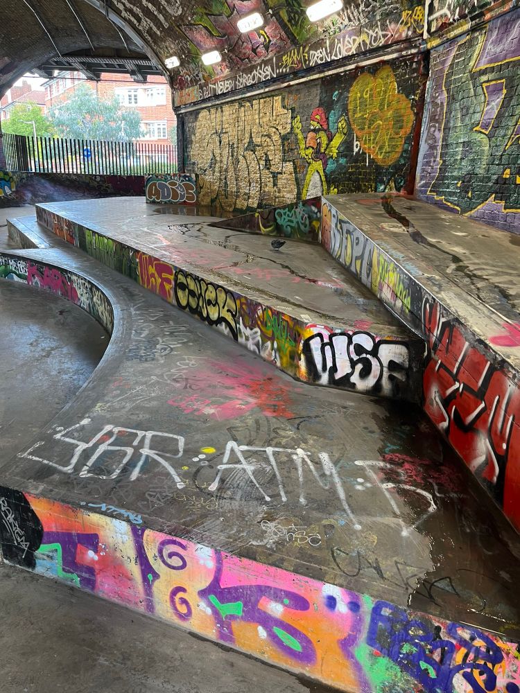 Railway arches turned skatepark brick walls with graffiti on ramps