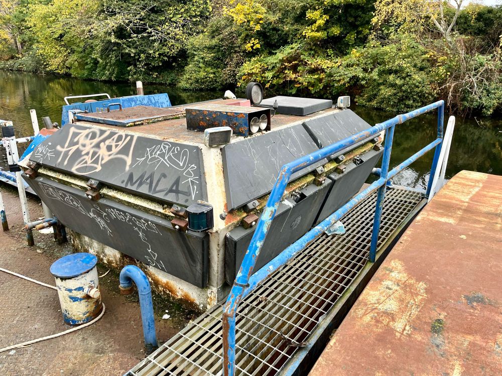 Canal barge motor house with hinged panels and grated floor and handrail