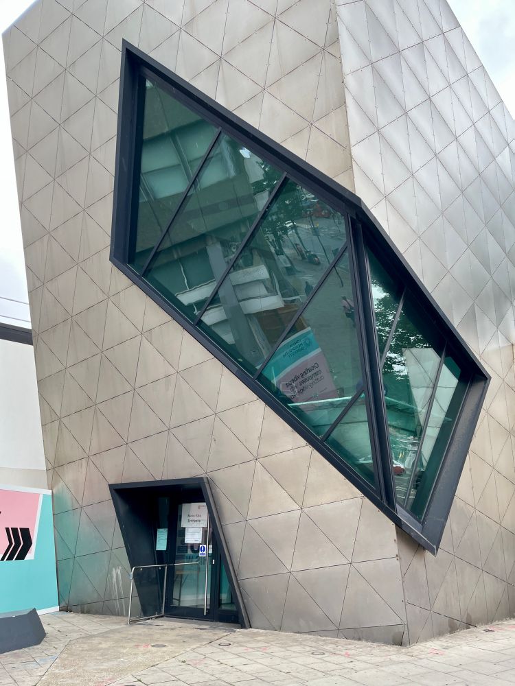 Building clad with embossed stainless steel panels and genetic window cut into the building