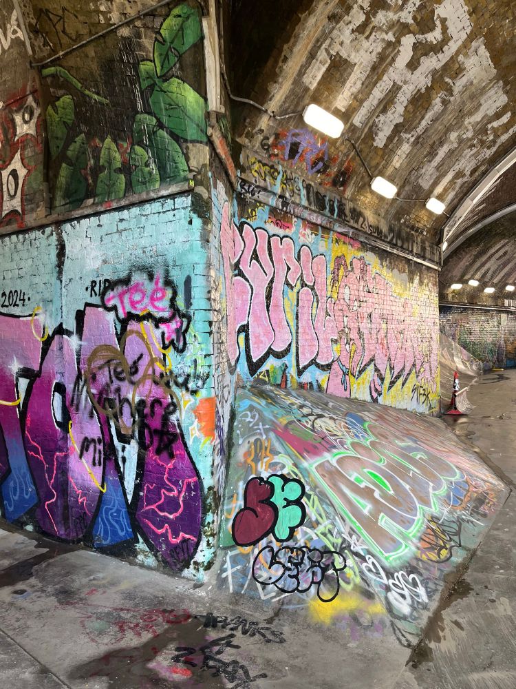 Railway arches turned skatepark brick walls with graffiti on ramps