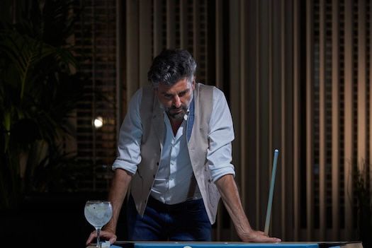 Exasperated man looking down at what is presumably a pool table, but it’s cropped out so you can’t tell for sure