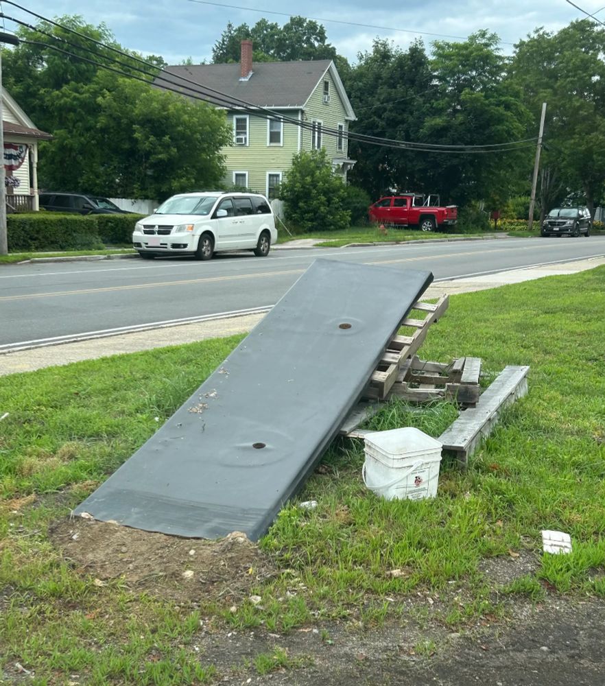 A stack of pallets on the side of a road with a huge board on top forming a big jump