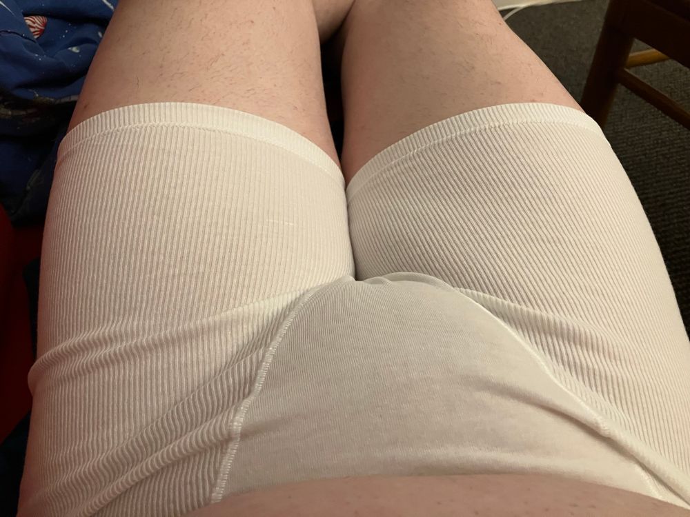 A nullo wearing white underwear without a flap in the crotch. The photo has the ends of the legs at the top of the frame, and a bit of the stomach is at the bottom of the frame. 
