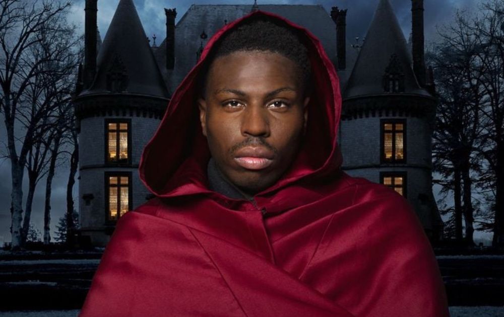 Marcus, avec la cape bordeaux des Traîtres, devant le château de l’émission (photomontage)