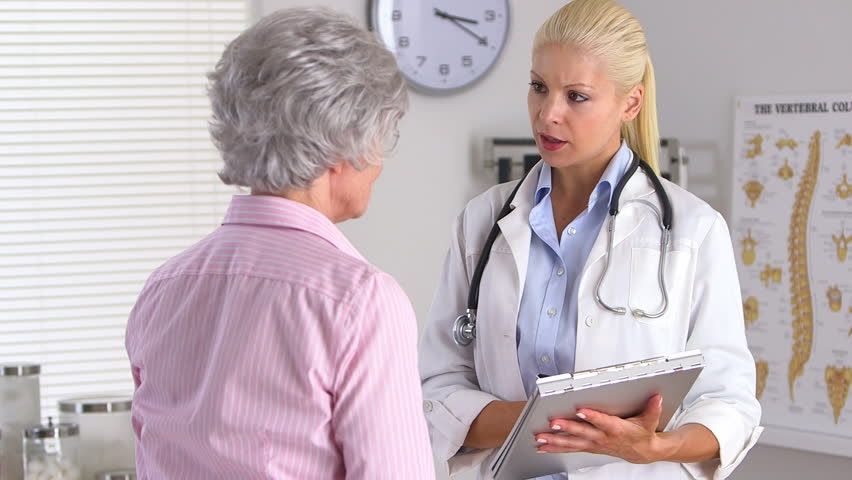 Une dame aux cheveux gris consulte une docteure qui a l'air contrariée