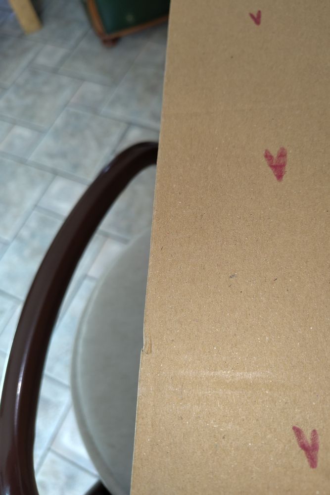 Carton d'emballage orné de quelques cœurs rouges.