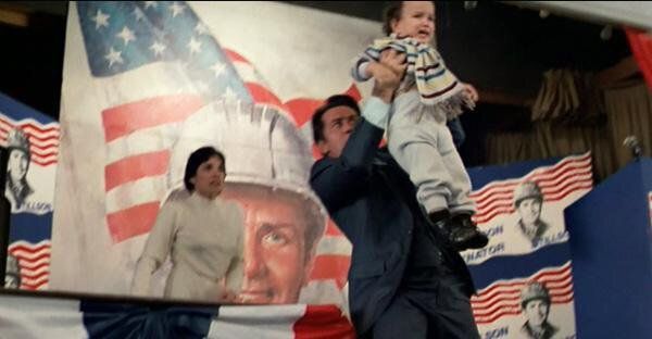 Still taken from the movie "The Dead Zone" of presidential candidate Stillson (Michael Sheen) holding up a baby to use as a shield against a sniper.