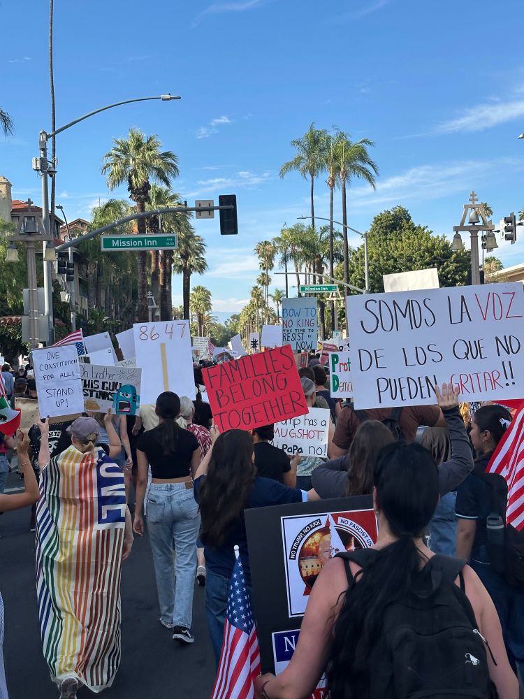 Protesters marching, holding up signs and flags
