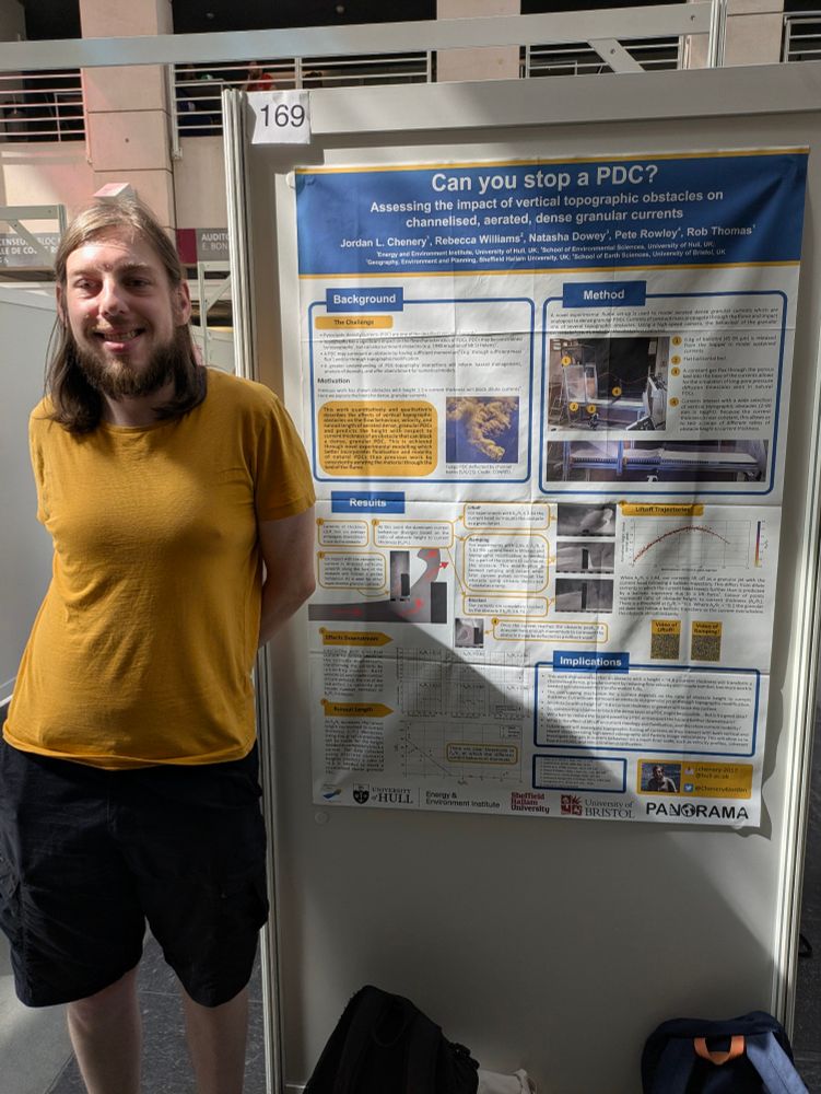 Photograph of a man standing in front of an academic conference poster