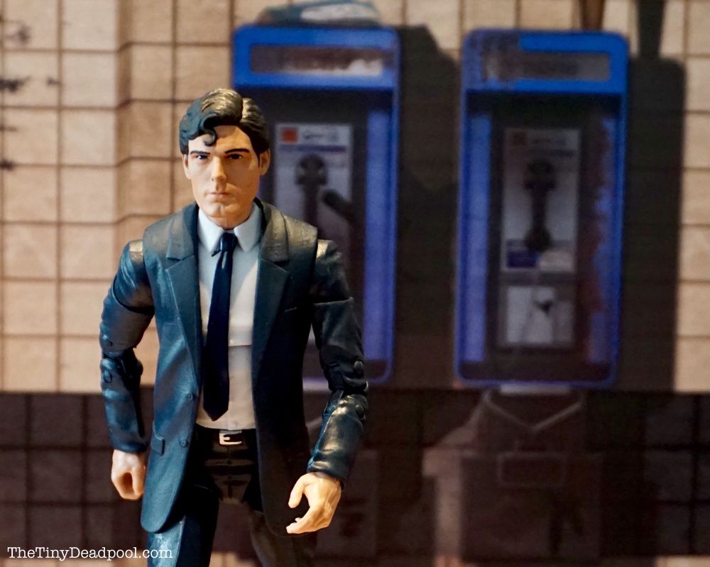 Clark Kent walks away from a public wall phone which is not a phone booth