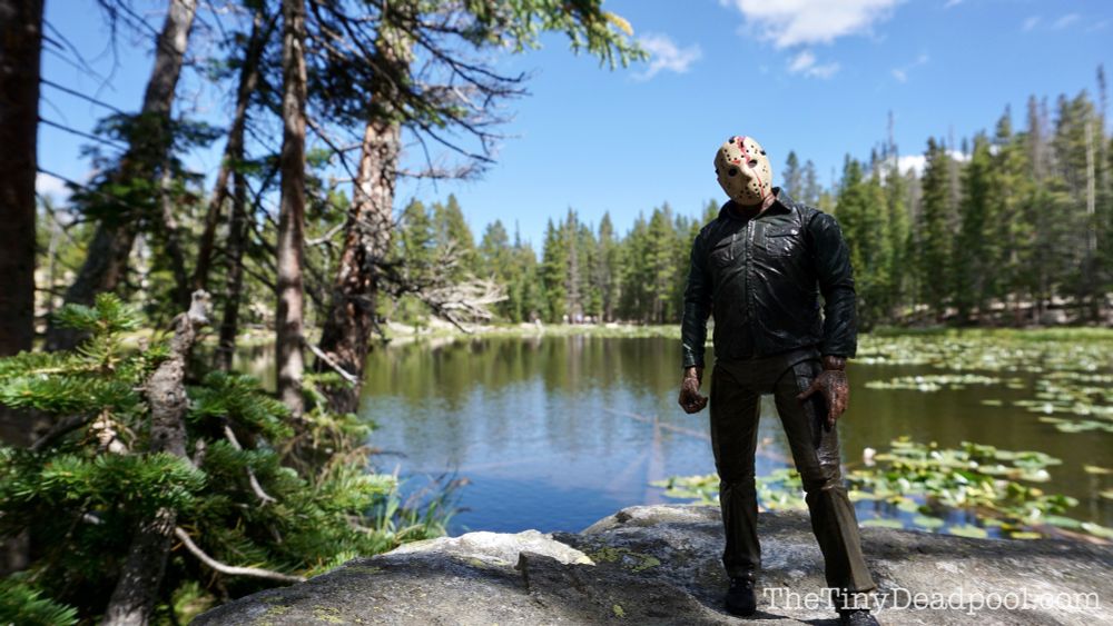 Jason Vorhees takes a break from killing and haunting your soul to pose for a picture in front of Nymph Lake at rocky mountain national park- picture is of an action figure made by NECA toys