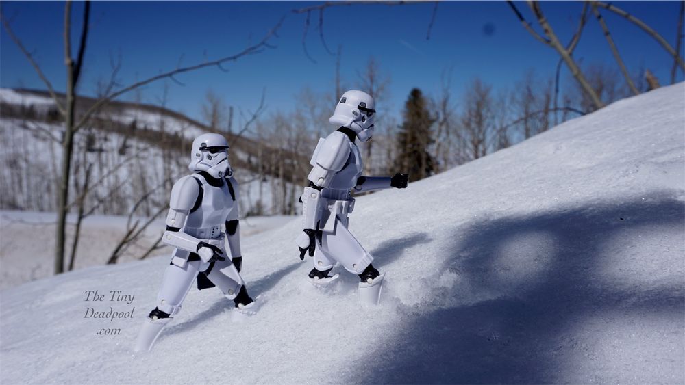 Two stormtroopers walking up a snow covered hill from bottom left to top right using Hasbro black series six inch scale action figures 