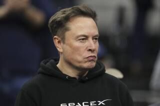 Elon Musk looking dour in a black hoodie