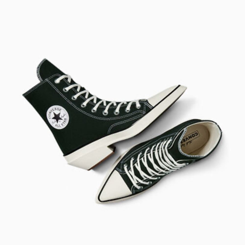 A black and white converse shoe but it’s a pointy heeled boot 