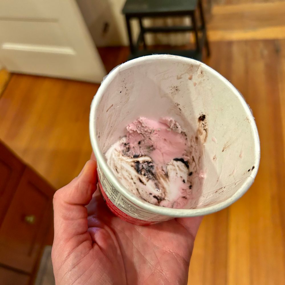 Pint container of ice cream with roughly a tablespoon and a half on one side of the bottom