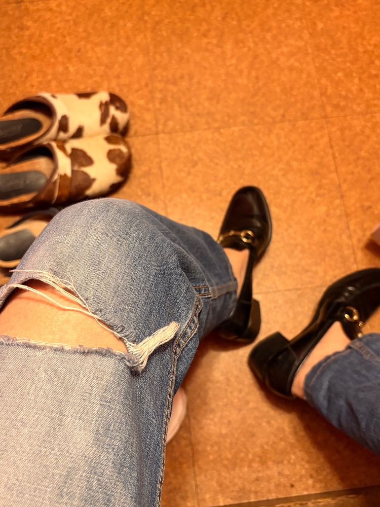 右に大きく穴の空いたジーンズを履いているところ